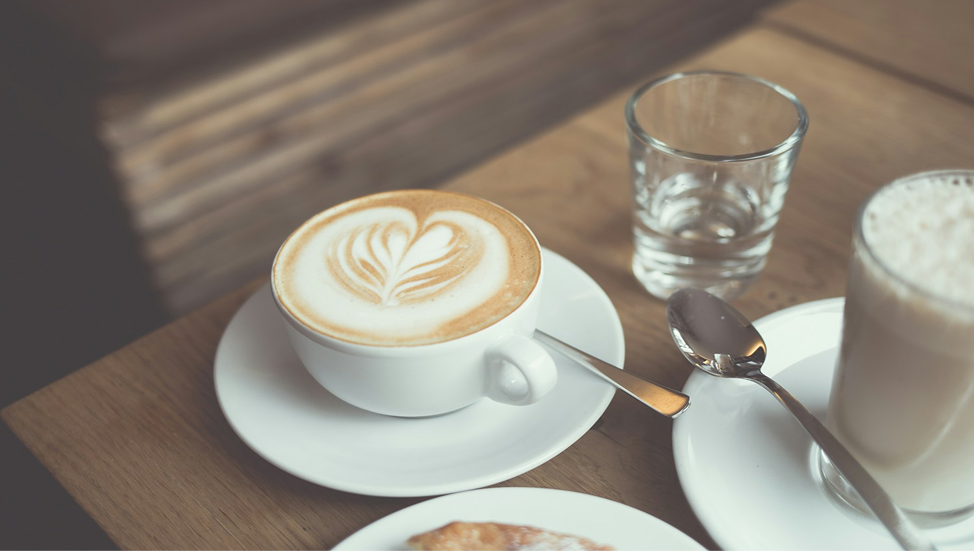 カフェラテが置かれた木のテーブルの背景